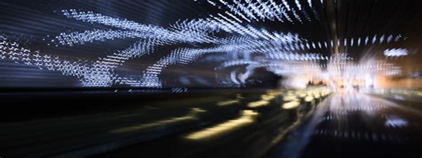 dark tunnel with lights of fast moving cars